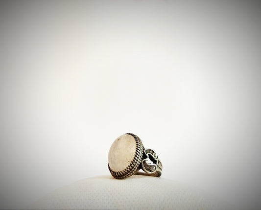 a silver ring sitting on top of a white surface
