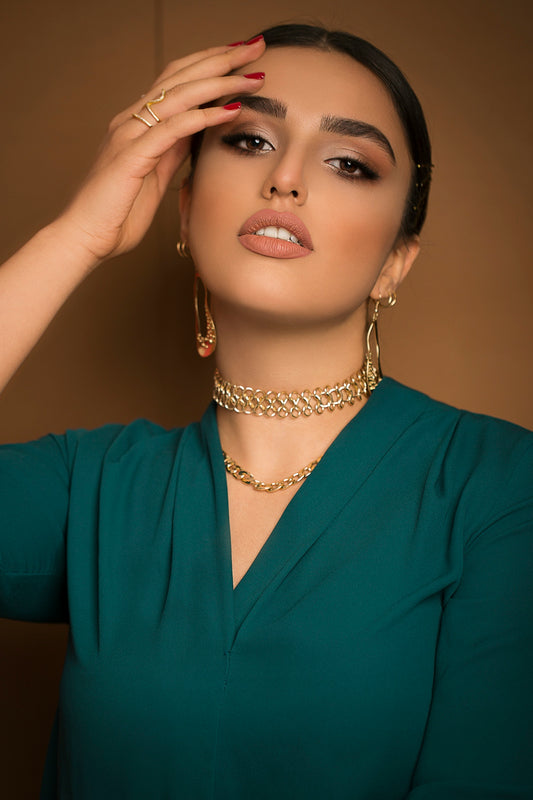 A woman in a green dress holding her hands to her face