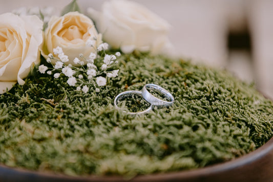 silver and gold rings on green textile