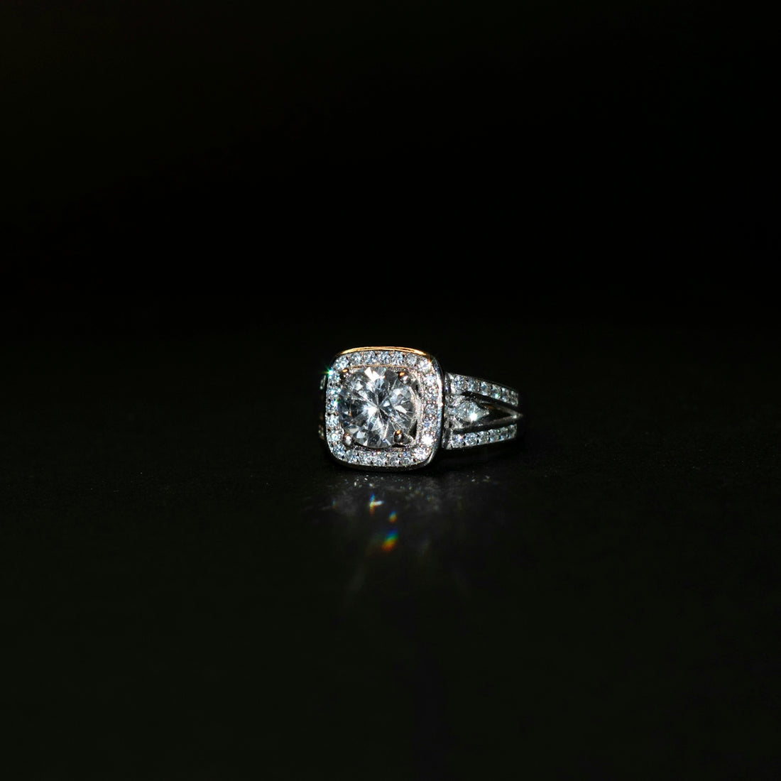 a diamond ring on a black surface