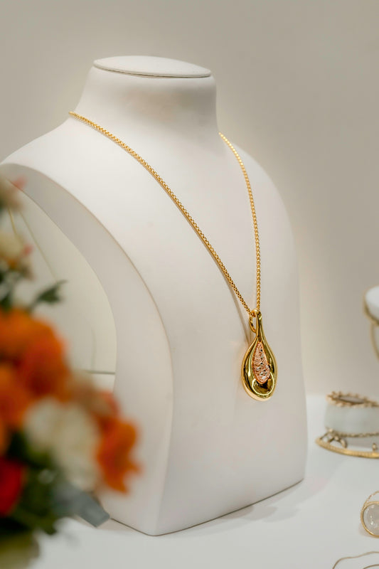 a white mannequin with a gold necklace on it