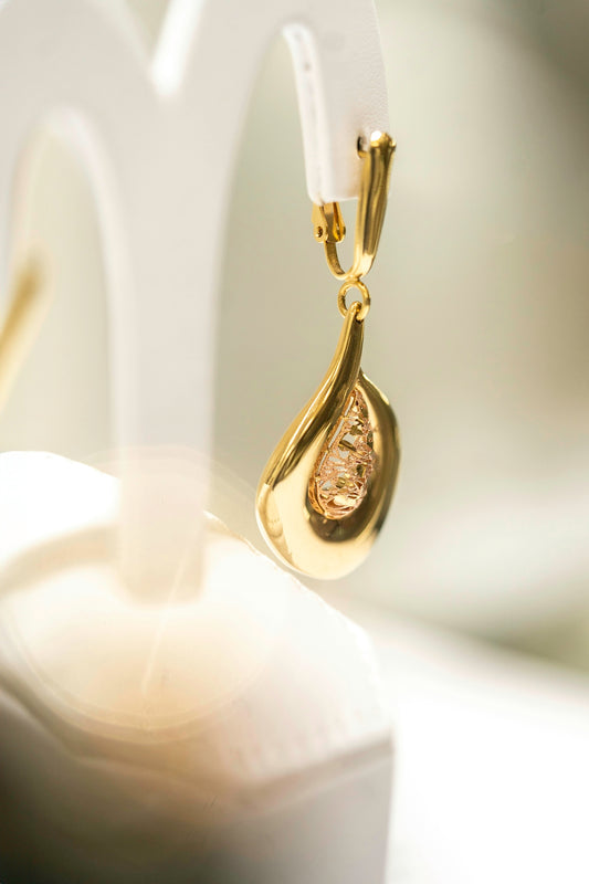 a close up of a pair of gold earrings