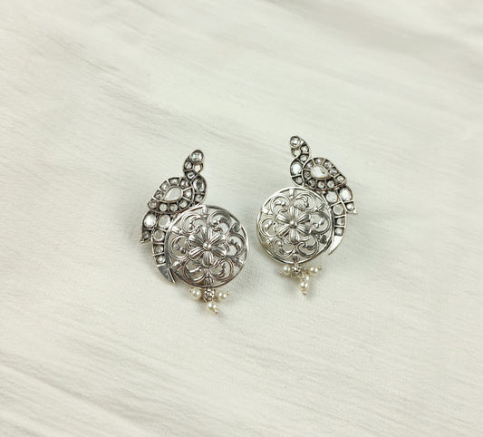 a pair of silver colored earrings on a white background