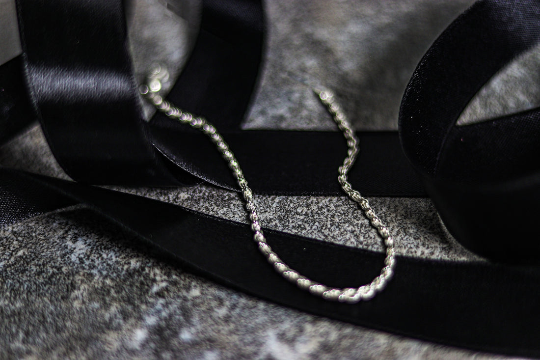 A pair of headphones sitting on top of a black ribbon